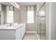 Modern bathroom with double sinks, white cabinets, decorative lighting, and a glass-enclosed shower at 6528 Domizio Dr, Winter Haven, FL 33884