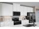 Bright kitchen with white cabinets, stainless steel appliances, granite countertops, and a modern backsplash at 6528 Domizio Dr, Winter Haven, FL 33884