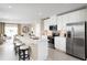 Modern kitchen with stainless steel appliances, center island with barstool seating and an open-concept to the living area at 6528 Domizio Dr, Winter Haven, FL 33884
