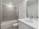 Bright bathroom featuring a tub-shower combo, neutral gray tiling, and a white vanity at 5281 Luisa Ct, St Cloud, FL 34771