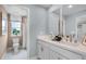 Bathroom features dual sinks, two mirrors, a view of a glass shower, and light blue walls at 823 Emerald Grove Dr, Apopka, FL 32703