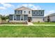 Charming two-story home with a manicured lawn, stone accents, and a welcoming front porch in a desirable neighborhood at 823 Emerald Grove Dr, Apopka, FL 32703