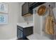 Well-organized mudroom with dark cabinetry, a sink, decorative artwork, and convenient storage hooks for accessories at 823 Emerald Grove Dr, Apopka, FL 32703