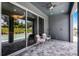 Covered patio with neutral stone flooring, two chairs, view of a pool, and sliding glass doors at 823 Emerald Grove Dr, Apopka, FL 32703