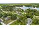 Stunning aerial view of a lakeside home featuring lush landscaping, sprawling lawn, and serene water views at 1148 Rosetta Dr, Deltona, FL 32725