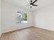 Bright bedroom with a modern ceiling fan, wood-look flooring, and a large window offering ample natural light at 1148 Rosetta Dr, Deltona, FL 32725