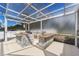 Outdoor kitchen area under screened enclosure with granite counters and stainless steel gas grill at 1148 Rosetta Dr, Deltona, FL 32725
