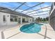 Spacious pool area with a screened enclosure, modern bar, and ample seating, perfect for outdoor enjoyment and relaxation at 1148 Rosetta Dr, Deltona, FL 32725