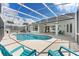 Beautiful pool area with turquoise chairs, screened-in enclosure and an outdoor bar, perfect for relaxation and entertainment at 1148 Rosetta Dr, Deltona, FL 32725