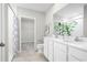 Bright bathroom featuring double vanity, walk-in shower with patterned curtain, and open view into walk-in closet at 1203 Port Blue Way, Lady Lake, FL 32159