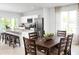 Dining room features a wooden dining table set, alongside the open kitchen and a view of the outdoors at 1203 Port Blue Way, Lady Lake, FL 32159