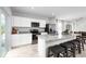 Bright, modern kitchen featuring stainless steel appliances, granite counters, island with bar seating, and tile floors at 1203 Port Blue Way, Lady Lake, FL 32159