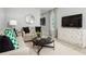 Well-lit living room featuring sofas, a round center table, a cabinet with a TV, and patterned curtains at 1203 Port Blue Way, Lady Lake, FL 32159
