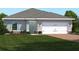 Charming single-story home with a manicured lawn and a two-car garage, offering curb appeal at 1408 Laramie Way, Haines City, FL 33844
