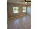 A bedroom with neutral walls, tile floors, and a ceiling fan with two large windows at 2200 S Palmetto Ave # E050, South Daytona, FL 32119