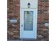 Close-up of the front door of a brick townhome with a mailbox and a wall light at 2200 S Palmetto Ave # E050, South Daytona, FL 32119