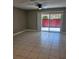 Spacious living room featuring tile flooring and access to a private patio at 2200 S Palmetto Ave # E050, South Daytona, FL 32119