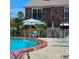 Inviting community pool with lounge chairs and umbrella-covered tables for relaxing by the water at 2200 S Palmetto Ave # E050, South Daytona, FL 32119