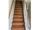 Carpeted staircase with wooden handrails leading to the upper level of the home at 2200 S Palmetto Ave # E050, South Daytona, FL 32119