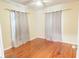 Cozy bedroom with gleaming hardwood floors and simple curtains at 423 E Kaley St, Orlando, FL 32806