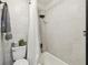 Cozy bathroom features tiled walls, a shower-tub combo, and a plant on top of the toilet at 7289 Lake Floy Cir, Orlando, FL 32819