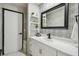 Stylish bathroom featuring a modern vanity with decorative tile and a sleek black-framed mirror at 7289 Lake Floy Cir, Orlando, FL 32819