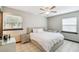 This neutrally decorated bedroom features tile floors, multiple windows, and white linens at 7289 Lake Floy Cir, Orlando, FL 32819