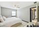 A neutral bedroom with white linens, tile flooring, and a view to another room at 7289 Lake Floy Cir, Orlando, FL 32819