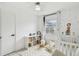 A white crib and white shelving with bins are featured in this bedroom at 7289 Lake Floy Cir, Orlando, FL 32819