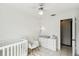 This bedroom features a ceiling fan, white dresser, and a changing table at 7289 Lake Floy Cir, Orlando, FL 32819