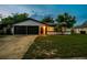 Attractive one-story home features a two-car garage and green lawn at 7289 Lake Floy Cir, Orlando, FL 32819