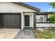 Up close front view of the home's entry way, garage, and yard at 7289 Lake Floy Cir, Orlando, FL 32819