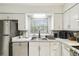 Modern kitchen features stainless steel appliances, white cabinets, subway tile backsplash, and a bright window at 7289 Lake Floy Cir, Orlando, FL 32819