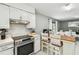 Bright kitchen featuring stainless steel range, a breakfast bar and view of dining area, perfect for entertaining at 7289 Lake Floy Cir, Orlando, FL 32819