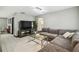 Inviting living room featuring a gray sectional sofa, a large television, and bright, neutral wall colors at 7289 Lake Floy Cir, Orlando, FL 32819