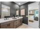 This bathroom features a double vanity with dark fixtures, neutral walls, and access to the main bedroom at 847 Emerald Grove Dr, Apopka, FL 32703
