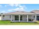 Rear exterior showing the covered patio with outdoor seating and sliding glass doors at 847 Emerald Grove Dr, Apopka, FL 32703