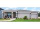 Charming single-story home featuring a three-car garage, brick accents, covered entry, and manicured lawn at 847 Emerald Grove Dr, Apopka, FL 32703