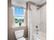 Bright bathroom featuring a combination shower and tub, toilet, large window, and neutral colors at 855 Emerald Grove Dr, Apopka, FL 32703