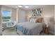 Bedroom features a striking accent wall art, cozy round chair, and a serene window view, creating a restful retreat at 855 Emerald Grove Dr, Apopka, FL 32703