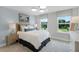 Serene bedroom with natural light streaming through windows, complemented by a cozy bed and a stylish nightstand at 855 Emerald Grove Dr, Apopka, FL 32703