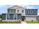 Two-story home boasts a combination of blue siding and decorative shingles at 855 Emerald Grove Dr, Apopka, FL 32703