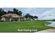 Community clubhouse near the water with a lush lawn, palm trees, and lovely landscaping at 3612 Northwoods Dr, Kissimmee, FL 34746