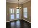 Bright dining area features elegant chandelier, patio access, and dark wood floors at 3612 Northwoods Dr, Kissimmee, FL 34746