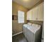 Laundry room with white cabinets, tile floors, and a front load washer and dryer at 3612 Northwoods Dr, Kissimmee, FL 34746