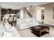 Open-concept living room with a plush sofa, staircase, and seamless flow into the kitchen and dining area at 3878 Isle Royal Pl, Apopka, FL 32712