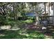 The backyard has a green open space with some trees, plants and a fence at 5635 Kimball Rd, Mulberry, FL 33860