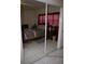 Bedroom with large mirrored closet doors, tile flooring and window at 5635 Kimball Rd, Mulberry, FL 33860