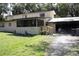 Inviting home exterior with a screened porch, attached garage, and mature trees. The house number is prominently displayed at 5635 Kimball Rd, Mulberry, FL 33860