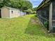 This backyard features lush green grass, sheds, and covered patio at 774 Hendrix Ave, Orlando, FL 32825